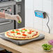 An AvaWeigh pizza scale on a counter in a pizza parlor.