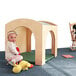 A baby sitting in a Whitney Brothers wooden reading retreat with a green floor mat inside.