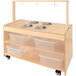 A Whitney Brothers wooden sensory play kitchen with bowls on a wood surface.