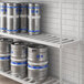 A Regency bottom shelf with metal beer kegs on it.
