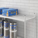 A Regency top shelf for a 20" x 72" keg rack holding blue boxes of beer.