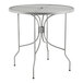 A Lancaster Table & Seating Harbor Gray 30" round outdoor table with metal legs.