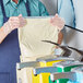 A man in a blue shirt using a Heinz mayonnaise dispenser pouch to fill a bag with liquid.