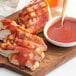 A plate of grilled chicken and bacon with Open Pit BBQ sauce on a wooden board.