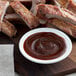 A plate of ribs with Bull's-Eye barbecue sauce on a table.