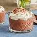 A glass cup of JELL-O chocolate pudding with whipped cream and chocolate shavings.