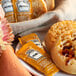 A plate with a bagel and Heinz honey packets on a table.