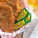 A plate of fried food with a ReaLemon lemonade packet and a glass of beer.