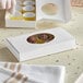 A white 1-piece candy box with an oval window filled with chocolate cups.