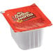 A white Mrs. Buttersworth's syrup portion container with a red label.