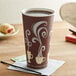 A Dart ThermoGuard paper hot cup with coffee on a table.