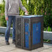 A woman standing next to a blue and black Cerobin dual-stream trash can.