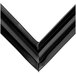 A close up of a black plastic corner piece with two black lines.