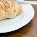 A croissant on a Tuxton Chicago bright white china plate.