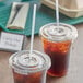 Two plastic cups of brown liquid with EcoChoice PLA straws on a table.