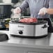 A close up of meat being cooked in a Galaxy countertop roaster oven.