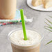 A close up of a green EcoChoice PLA straw in a smoothie.