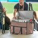 A man putting cans in a Choice brown large insulated cooler bag.
