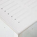 A white metal rear corner drainboard surface with lines on it.