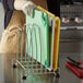 A woman using a San Jamar cutting board rack to store cutting boards.