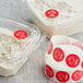 A roll of red and white Point Plus Tuna Permanent labels.