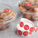 a group of chicken in plastic containers next to a roll of stickers