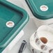 A roll of Noble Products Thursday day of the week stickers on a green plastic container.