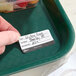 A removable hospital label with spaces for diet, patient name, and room number being applied to a green tray.