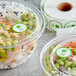 A roll of Point Plus green "Nut Free" labels on a plastic container of food.
