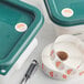 A roll of Noble Products green and white Saturday 1" clock labels on a countertop.