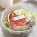 A plastic container of vegetables with a Noble Products Permanent Hospital label on the counter.