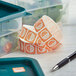 A plastic container of food with a Noble Products Saturday dissolvable label on it.
