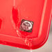 A red plastic tray with a white circle sticker with black text on it.