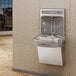 An Elkay stainless steel wall mount water fountain with a bottle filling station over a sink.