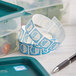 A roll of Noble Products Monday dissolvable day of the week stickers next to a pen on a counter.