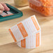 A roll of removable orange and white Saturday day of the week labels for food storage and organization.