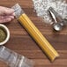 A hand using a Clear Line seal top plastic bag to hold spaghetti next to bowls of flour and spices.