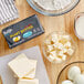 A table with ingredients for baking including a bowl of Violife Plant-Based Vegan Salted Butter cubes.