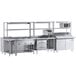 A Chef's Counter stainless steel serving line with a sandwich prep table, steam table, and work table in a commercial kitchen.