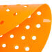 An orange oval Lavex plastic urinal screen with holes.
