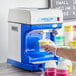 A person using a Carnival King ice shaver to make snow cones.