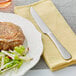 A plate of steak and salad with an Acopa Vernon steak knife on the table.