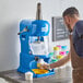 A man using a Carnival King block ice shaver to make ice.