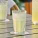 A close-up of a glass of DominAde lemon drink mix on a coaster with ice.