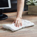 A hand wiping a counter with a white Choice terry bar towel.