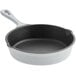 A white enameled cast iron skillet with a black interior and handle.