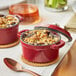 A red Valor mini cast iron pot with a cover filled with cranberry apple food.