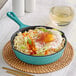 A Valor Aqua Sky enameled cast iron skillet with noodles, an egg, and vegetables.