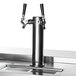 A stainless steel Beverage-Air beer tap with black handles on a counter.