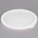 A white plastic lid on a gray surface.